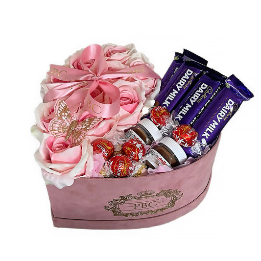 Large velvet pink box containing pink flowers, lindors, diary milk, and mini Nutellas 